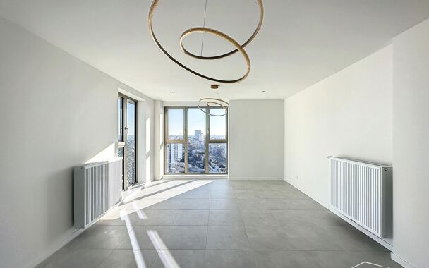 Luxe nieuwbouw appartement op de 20e verdieping met 270 graden uitzicht over Antwerpen, Park Spoor Noord, het Eilandje en de dokken. De lichtrijke leefruimte (ca. 26 m&sup2;) met open  keuken (ca. 6 m&sup2;) is voorzien van een keramische kookplaat, dampkap, koel