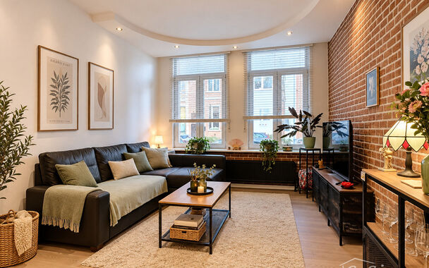 Dit charmante en instapklare appartement combineert een warme uitstraling met een praktische indeling. De karaktervolle bakstenen accentmuur, grote raampartijen en mooie lichtinval geven de leefruimte meteen een gezellige en authentieke sfeer.
De ruime wo