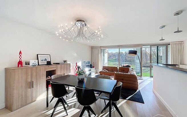 Lichtovergoten en zonnig appartement met een prachtig open uitzicht op de holes van de Golf van Brasschaat. Bij binnenkomst een ruime inkomhal met apart toilet. De uitnodigende woon- en eetkamer op parketvloer (ca. 37m&sup2;), biedt toegang tot het zonnige in