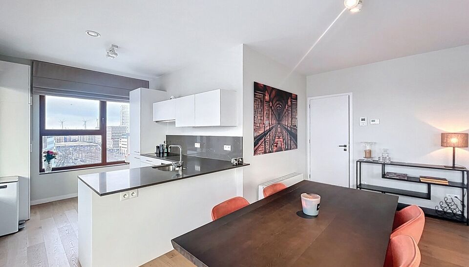 Verzorgd volledig ingericht hoekappartement op de 8e verdieping met een open uitzicht op het MAS en over de Leie. Inkomhal met vestiairekast en apart toilet. Ruime woon- en eetkamer op parketvloer (ca. 36m&sup2;) welke toegang geeft tot het overdekte terras. 