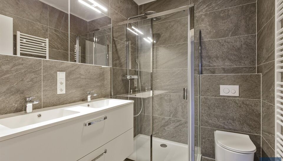 Verzorgd volledig ingericht hoekappartement op de 8e verdieping met een open uitzicht op het MAS en over de Leie. Inkomhal met vestiairekast en apart toilet. Ruime woon- en eetkamer op parketvloer (ca. 36m&sup2;) welke toegang geeft tot het overdekte terras. 