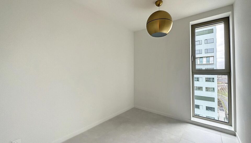 Luxe nieuwbouw appartement op de 20e verdieping met 270 graden uitzicht over Antwerpen, Park Spoor Noord, het Eilandje en de dokken. De lichtrijke leefruimte (ca. 26 m&sup2;) met open  keuken (ca. 6 m&sup2;) is voorzien van een keramische kookplaat, dampkap, koel