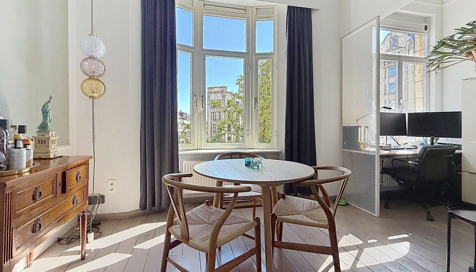 Charmant instapklaar appartement op de 2e verdieping met aangenaam open uitzicht. Inkomhal met vestiairekast. Lichtrijke woonkamer (ca. 22m&sup2;) op authentieke plankenvloer en een schouwelement. Aansluitend de half open keuken voorzien van gasfornuis, dampk