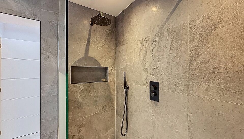 Bij het betreden van dit volledig gerenoveerde appartement wordt u verwelkomd in een stijlvolle inkomhal met een elegante, afgeronde deuropening.
Direct aan de inkom bevindt zich een bureauruimte met parketlaminaat en een gloednieuw raam, ideaal voor thui