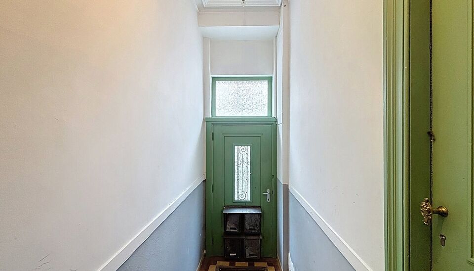 Bij het betreden van dit volledig gerenoveerde appartement wordt u verwelkomd in een stijlvolle inkomhal met een elegante, afgeronde deuropening.
Direct aan de inkom bevindt zich een bureauruimte met parketlaminaat en een gloednieuw raam, ideaal voor thui