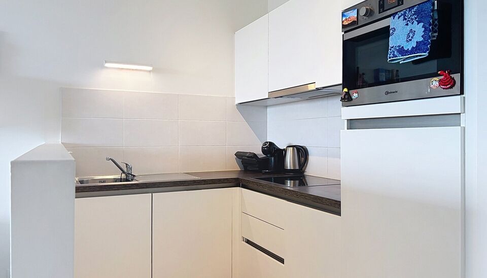 Dit energiezuinig appartement bevindt zich in een recent gebouw (2018) nabij het Rivierenhof. U betreedt het appartement via de inkomhal (ca.7 m&sup2;) met voldoende kastruimte en apart toilet. Lichtrijke woonkamer op keramische parket met een open keuken. De