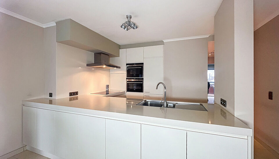 Dit ruime en goed onderhouden appartement met twee slaapkamers is gelegen op een centrale ligging nabij winkels, openbaar vervoer en vele uitvalswegen. Bij binnenkomst wordt u verwelkomd door een inkomhal met maatkast. De woon- en eetkamer, met een opperv