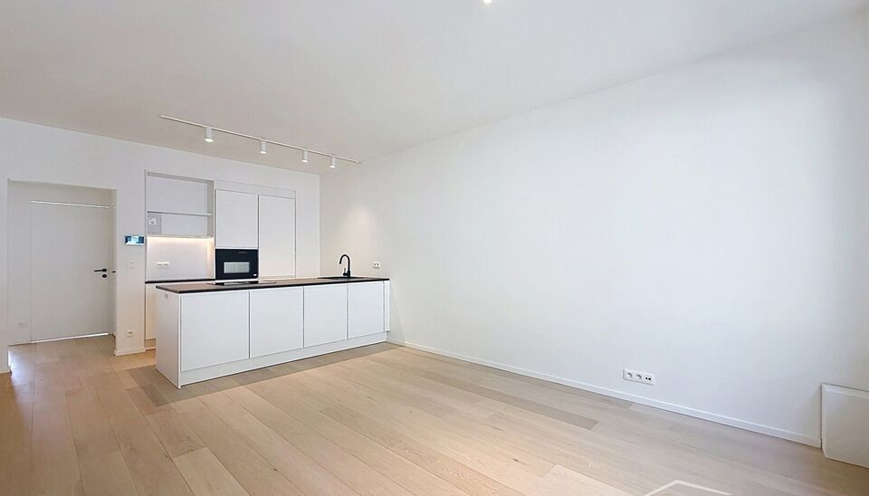 Luxueus gelijkvloers appartement met ruime zonnige tuin in de geliefde Vogeltjeswijk. Dit volledig gerenoveerde gelijkvloerse appartement combineert hedendaags comfort met een uitstekende ligging. Via de inkomhal met vestiaire bereikt u de lichtrijke leef