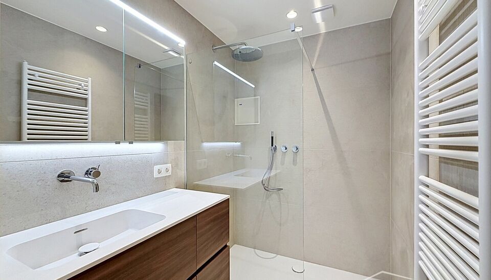 Luxueus gelijkvloers appartement met ruime zonnige tuin in de geliefde Vogeltjeswijk. Dit volledig gerenoveerde gelijkvloerse appartement combineert hedendaags comfort met een uitstekende ligging. Via de inkomhal met vestiaire bereikt u de lichtrijke leef