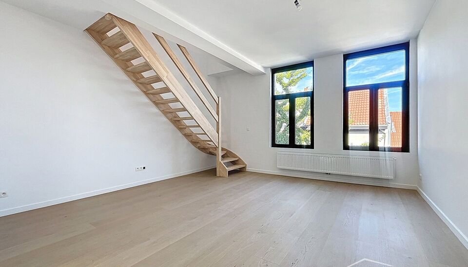 Tip top afgewerkt duplex appartement met terras en 2 slaapkamers.  Dit appartement biedt een perfecte balans tussen comfort en stijl, gelegen in de levendige en vernieuwende wijk Stuivenberg. Bij binnenkomst inkomhal met een apart toilet. De lichtrijke le