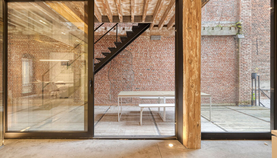 Welkom in Magazijn Julia &ndash; een voormalig pakhuis met paardenstallen en smidse, ontworpen in 1876 door Charles De Coster en gebouwd in een kenmerkende eclectische stijl. In dit monumentale gebouw bevindt zich op de eerste verdieping een luxueuze kantoor-